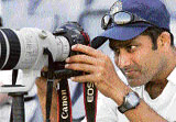 Anil Kumble takes a picture with a photographers camera during the first day of the warm-up match against Australian Capital Territory XI in Canberra on Thursday.