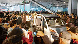 People flock around the Tata Nano car at the 9th Auto Expo in New Delhi