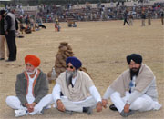Ex-MLA Sukhdarshan Singh Mrar (centre) opts to sit on the ground during the function