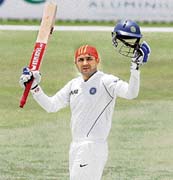 Virender Sehwag celebrates after scoring a century during their three-day cricket match against Australian Capital Territory (ACT) XI in Canberra on Saturday.