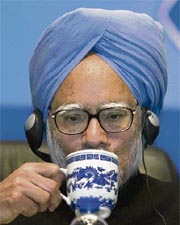 Manmohan Singh sips from a cup at the China-India Economic, Trade & Investment Cooperation Summit in Beijing on Monday.