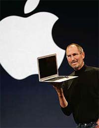 Apple CEO Steve Jobs smiles as he shows off the new Macbook Air, an ultra portable laptop, during his keynote speech at the MacWorld Conference and Expo in San Francisco, California