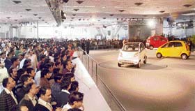 Visitors look at Tata Nano car on the last day of the 9th Auto Expo in New Delhi