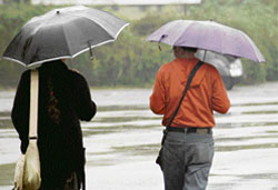 With umbrellas stretched, two students enjoy the rain, which lashed Jammu