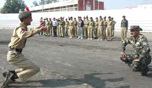 An NCC cadet smiles while doing an exercise to make amends for coming late at the Sports Stadium in Bathinda on Friday.