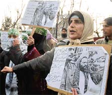 Members of the Jammu and Kashmir Muslim Khwateen Markaz holding placards in protest against the BJP for using harsh words against Afzal Guru, in Srinagar on Friday