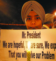Sikhs hold a candlelight vigil urging the visiting French President Nicolas Sarkozy to lift ban on wearing turbans in France, in front of the Bangla Sahib Gurdwara in the Capital on Saturday.