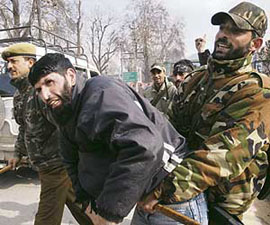 Policemen detain a Shia Muslim during a Moharram procession at Residency Road in Srinagar on Sunday. 