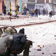 Kashmiri protesters provoke policemen during clashes between the protesters and the police in Srinagar