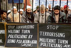 Jammu and Kashmir Salvation Movement chairman Zaffar Ahmed and senior Hurriyat leader Sheikh Abdul Aziz with party activists hold placards as they sit inside a cage during a hunger strike in Srinagar