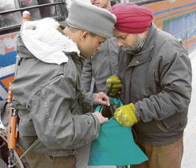 A CRPF jawan checks the bag of a Kashmiri resident during a cordon and search operation ahead of Republic Day celebrations in Srinagar