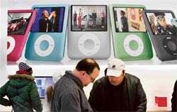 Apple Store customers look at a display of iPods in San Francisco, California, on Tuesday. Apple Inc. has reported a 57 per cent surge in first-quarter profit with net income soaring to $1.58 billion from $1 billion last year.