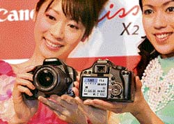 Models display the new 12.2 megapixel Canon EOS Kiss X2 digital SLR camera at a press preview in Tokyo on Thursday.