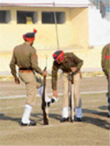 Policemen help each other before the final rehearsal for the Republic Day parade at Gandhi Ground in Amritsar