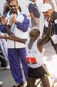Kenyas John Kelai celebrates after winning the Mumbai Marathon as Indian Olympic Association president Suresh Kalmadi applauds