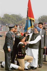 Prime Minister Manmohan Singh presents the NCC flag to a cadet during the NCC rally at Garrison Parade Ground in New Delhi