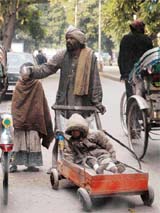 A beggar begs along with his children on the main road opposite Hotel Mehfil in Sector 17, Chandigarh; 