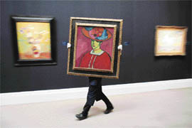 A Sotheby's employee holds a painting entitled 'Schokko mit Tellerhut', 1910, by Russian artist Alexej von Jawlensky on Tuesday at the Sotheby auction house in London. The painting is expected to fetch an estimated 6.5-8.5 million ( $13-17 million) when it is auctioned on Febuary 5, 2008, in London.