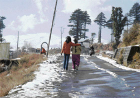 Two pilgrims seem to enjoy walking on a snow-covered road on way to Katra Vaishno Devi shrine near Kud, 110 km north of Jammu. 