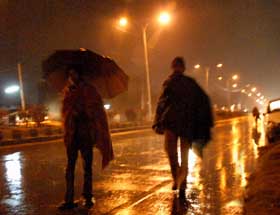 People walk in the drizzle late on Saturday evening in Bathinda. 