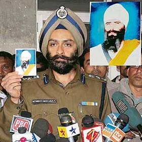 District police chief A.S. Chawala reveals the picture of Bakhsheesh Singh (inset), Nilokheri blast mastermind, to the media at the Mini-Secretariat in Karnal on Sunday evening