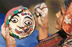 Subhadra Devi (70), an artisan from Bihar, works at her stall at the Surajkund Crafts Mela on Monday.  Reuters