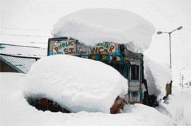 A truck seems to carry a boulder of snow at Gulmarg, which experienced 