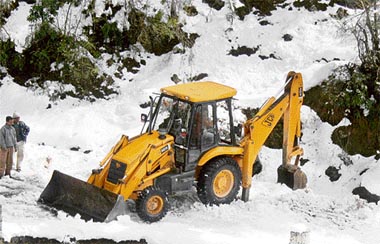 A JCB at work to clear snow on the Mandi-Karsog road in the Pandar area of Mandi district. The road has been blocked for two days.