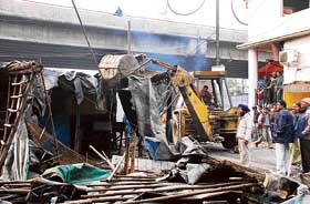 A JCB removes encroachments on the roadside in Ludhiana on Tuesday.