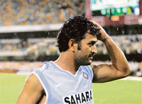 Mahendra Singh Dhoni leaves the field after play was called off because of rain