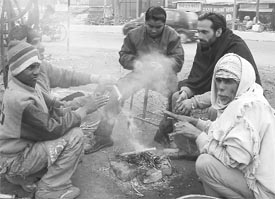 Slum-dwellers huddle together around a bonfire to keep themselves warm on a chilly morning in Ambala on Wednesday.
