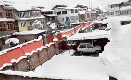 A view of fresh snowfall in Srinagar on Thursday. Rooftops are seen covered with a white blanket of snow.