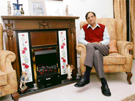 D.V. Bhatia sits besides his electric fireplace.