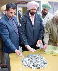 A police team with the silver coins found during the digging of the foundation of a house in old Rajpura on Friday.