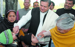 Chief Minister Sheila Dikshit and health minister Dr Yoganand Shastri administer pulse polio drops to children at the CMs residence in the Capital