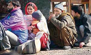 Srinagar-bound stranded passengers wait for their turn to board Air Force planes in Jammu on Saturday.