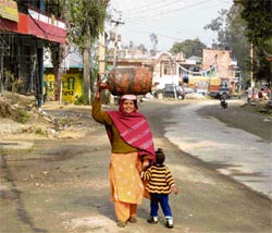 As dellivermen fail to supply LPG refills at the doorstep in the Mahadev area of Sundernagar, consumers like this woman have to make their own arrangements for collecting the cylinders.