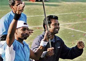 Prakash Amritraj celebrates along with team's non-playing captain Leander Paes after winning the singles match against Farrukh Dustov of Uzbekistan in the Davis Cup Tennis tournament in New Delhi