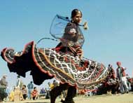 A Rajasthani dancer performs on the concluding day of the sports festival at Kila Raipur on Sunday; and (right) a man spits fire.