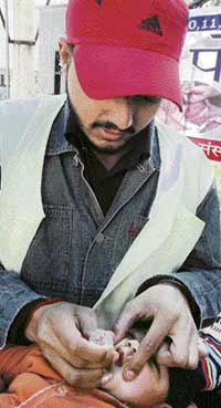 A health worker administers polio drops to a baby in Amritsar on Sunday. 