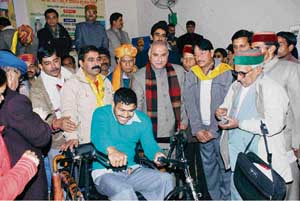 PWD minister Gulab Singh Thakur (centre) with NSS trust members and a differently-abled person, who was given a tricycle at a camp in Mandi.