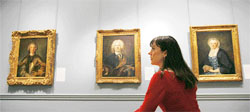 A woman looks at Jean-Marc Nattier's painting The Portrait of a Commander of the Order of the Knights of Malta