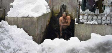 A resident braves the cold to take shower utilising water supply which was disrupted following heavy snowfall in Bhadarwah, 200 km from Jammu