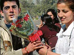 A young boy greets his beloved with flowers on Valentines Day at the Sukhna Lake in Chandigarh on Thursday.