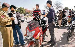 Vigilant police personnel check the antecedents of visitors at Sukhna Lake on Valentines Day in Chandigarh on Thursday.