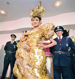 GORGEOUS IN Gold: A Japanese model walks the ramp in a $ 265,000 dress under the watchful eyes of two security guards. The dress has been made by a Tokyo jeweller and is embellished with 325 Austrian gold coins!