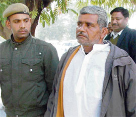 Raj Singh Dalal (right), whose revolver was allegedly used by a student to kill his schoolmate, Abhishek Tyagi, on December 11, is produced in a court in Gurgaon on Friday.