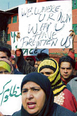 Members of the All India Centre for Urban Development shout slogans as they hold placards demanding their rehabilitation during a demonstration in Srinagar on Sunday.