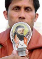 Yash Momi holds a bulb wherein he painted a picture of Guru Ravidas.