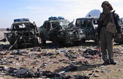 An Afghan policeman keeps watch at a blast site in Kandahar on Sunday. 